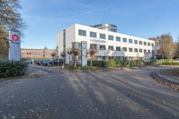 Kantoorgebouw Eemstede aan de Baarnsche Dijk in Baarn met een te huur-bord en parkeerplaatsen op de voorgrond.